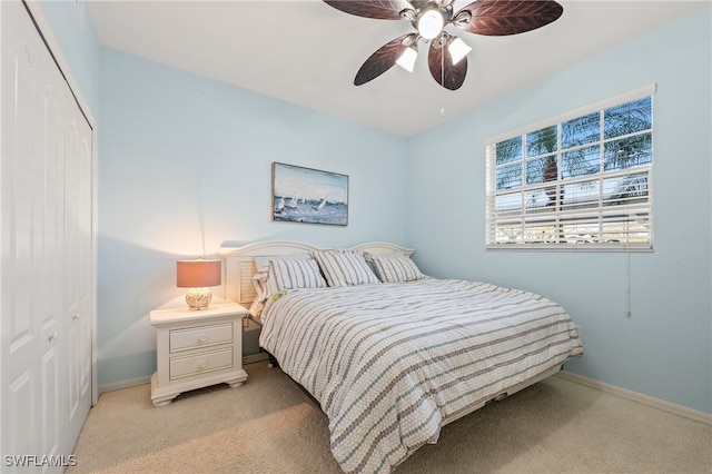 bedroom with ceiling fan, light colored carpet, a closet, and baseboards