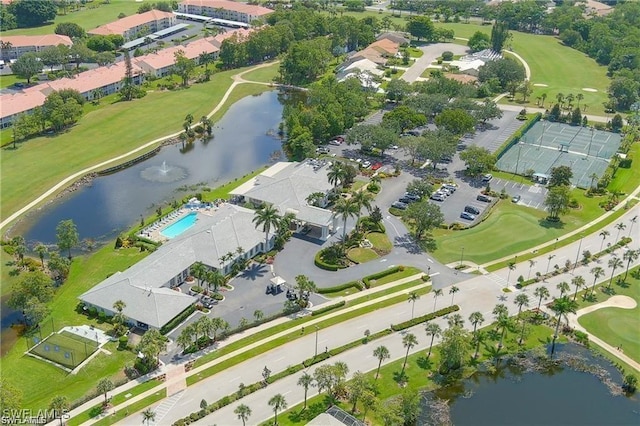 drone / aerial view featuring golf course view and a water view