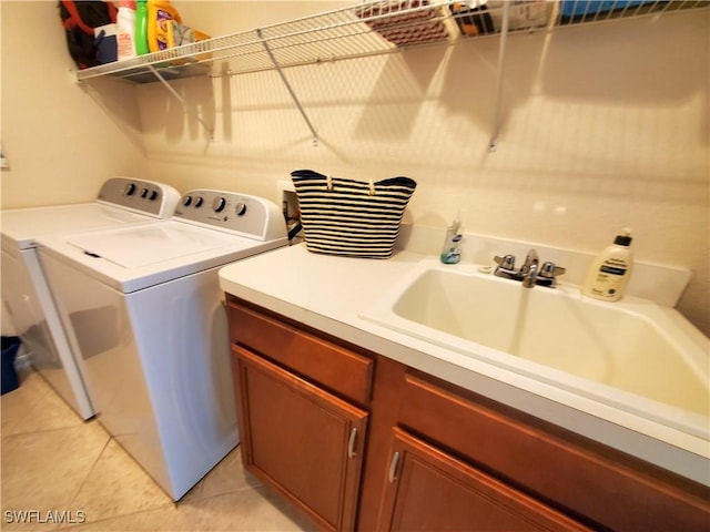 washroom featuring light tile patterned floors, cabinet space, separate washer and dryer, and a sink