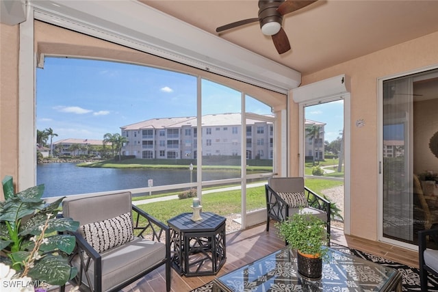 sunroom / solarium with a water view and ceiling fan