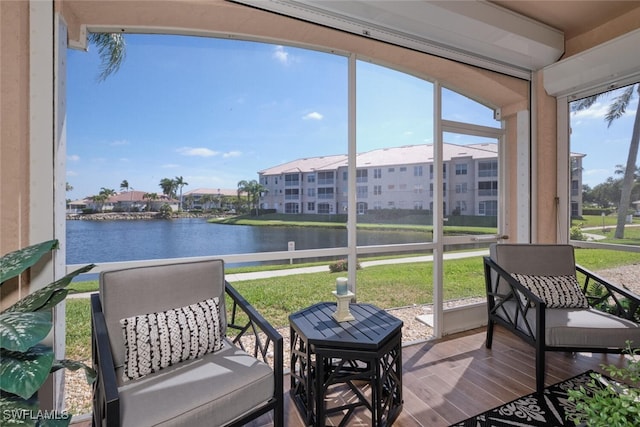 sunroom featuring a water view