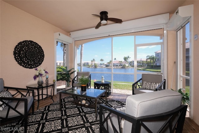 sunroom featuring ceiling fan, a water view, and plenty of natural light