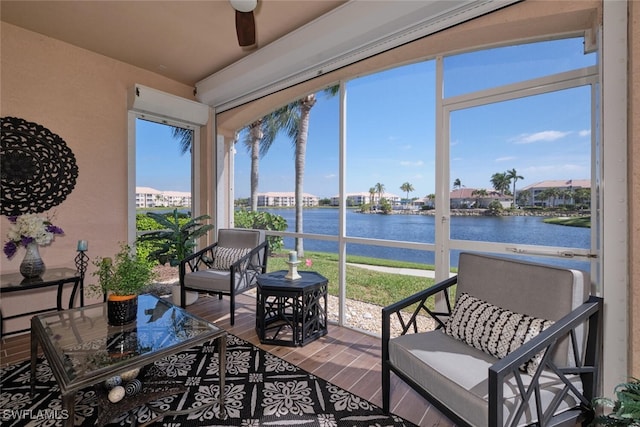 sunroom / solarium featuring ceiling fan, a water view, and a wealth of natural light