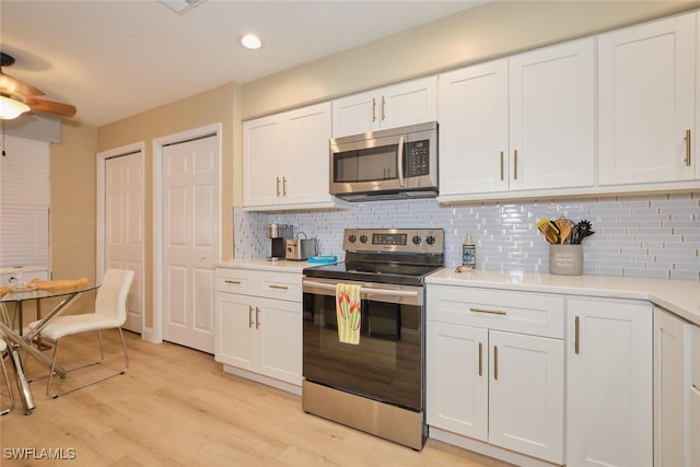 kitchen featuring backsplash, white cabinetry, and appliances with stainless steel finishes