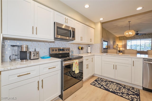 kitchen featuring sink, stainless steel appliances, white cabinets, and tasteful backsplash