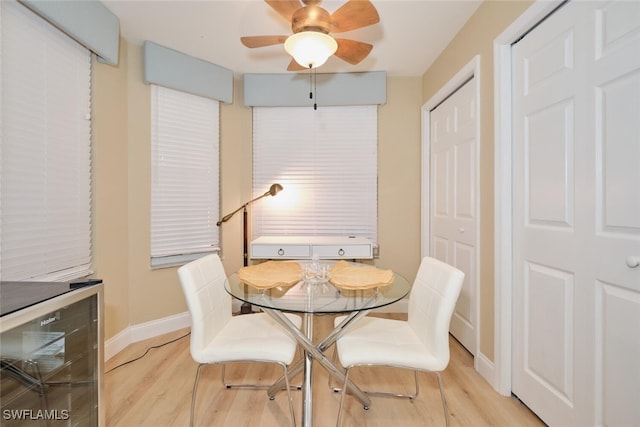 dining area featuring ceiling fan, light hardwood / wood-style flooring, and wine cooler