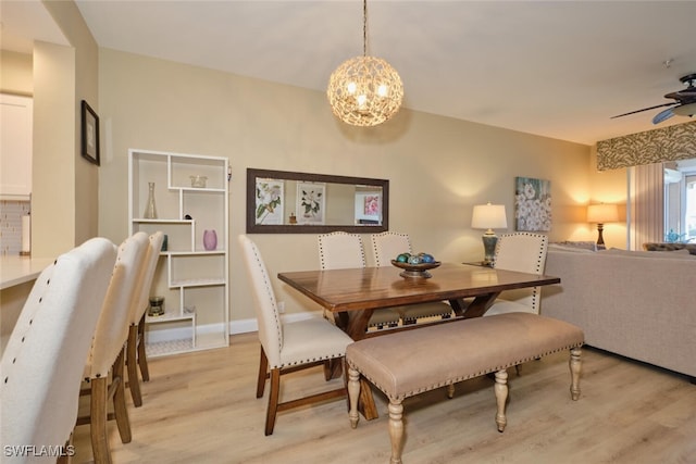 dining room with light wood-type flooring and ceiling fan with notable chandelier