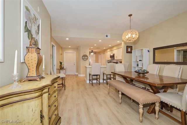 dining space with a chandelier and light hardwood / wood-style flooring