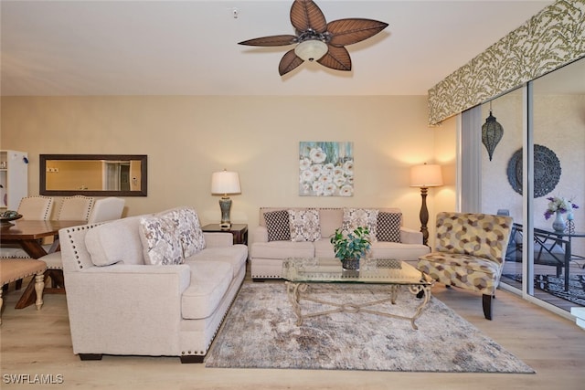 living room with ceiling fan and light hardwood / wood-style flooring