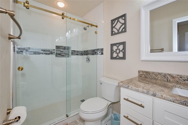 bathroom with vanity, toilet, and an enclosed shower