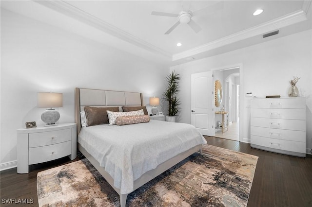 bedroom with crown molding, dark hardwood / wood-style flooring, and a raised ceiling