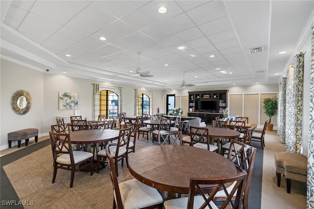 dining area with ceiling fan and a tray ceiling