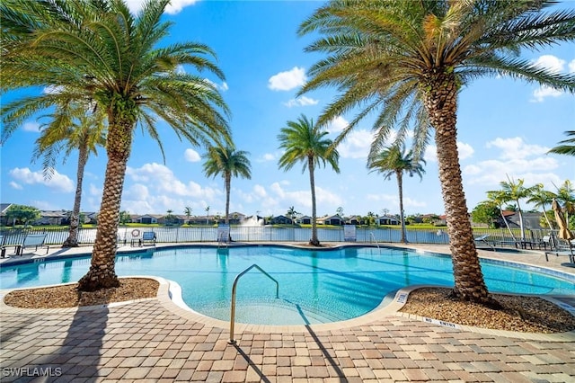 view of pool featuring a water view and a patio area