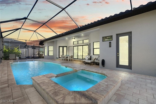 pool at dusk featuring an outdoor hangout area, a patio, ceiling fan, and glass enclosure