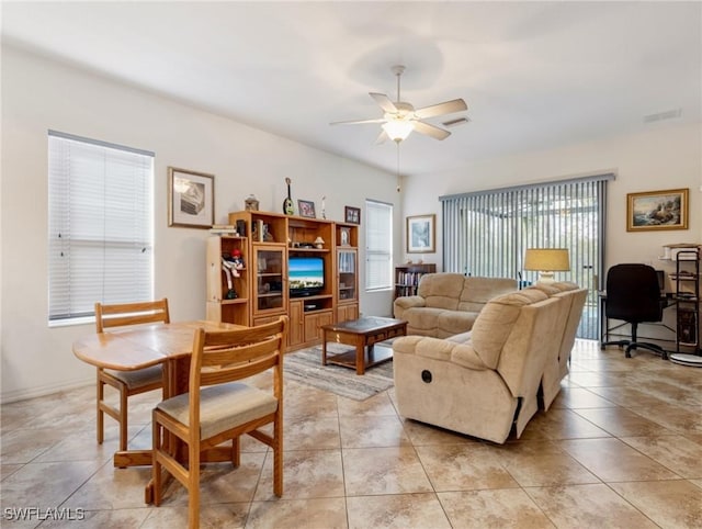 living room with ceiling fan, light tile patterned floors, and a wealth of natural light