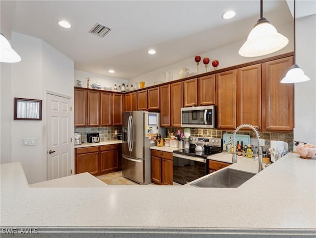 kitchen featuring sink, decorative light fixtures, backsplash, and appliances with stainless steel finishes