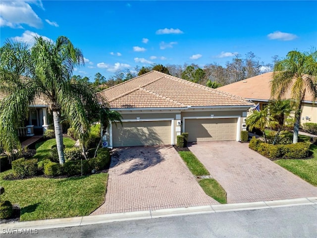 mediterranean / spanish home with a garage and a front yard