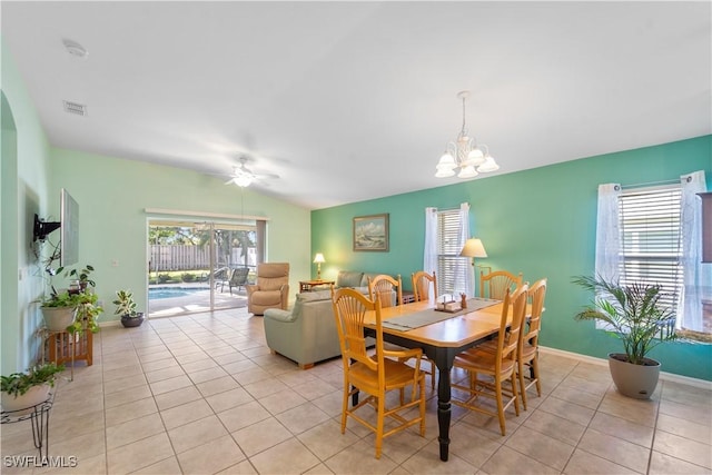 tiled dining space with vaulted ceiling, ceiling fan with notable chandelier, and a wealth of natural light