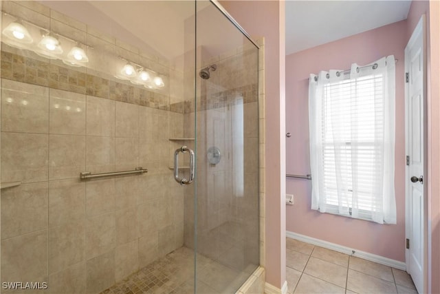 bathroom with tile patterned flooring, a wealth of natural light, and walk in shower