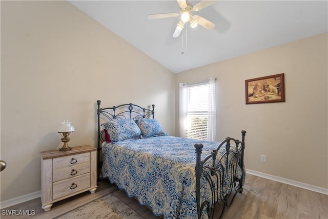 bedroom with ceiling fan, lofted ceiling, and wood-type flooring