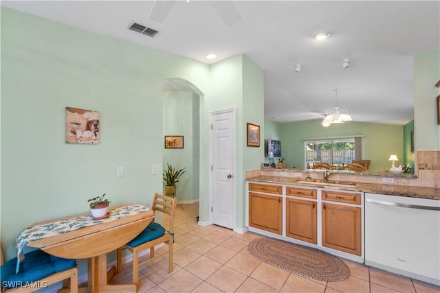 kitchen with lofted ceiling, sink, light tile patterned floors, dishwasher, and a chandelier