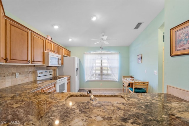 kitchen with sink, white appliances, stone countertops, ceiling fan, and decorative backsplash