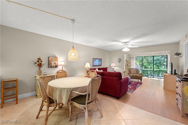 tiled dining room with ceiling fan and a textured ceiling