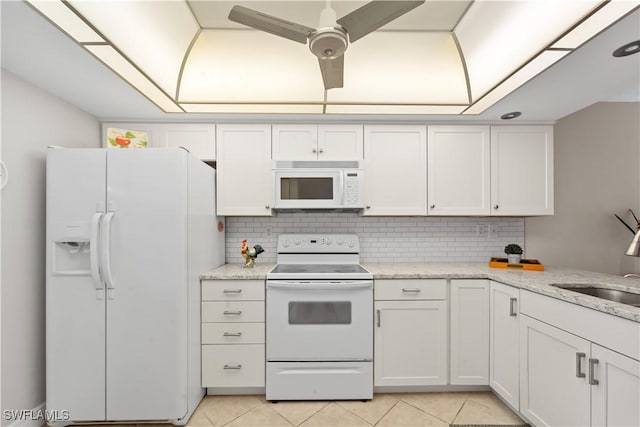 kitchen featuring sink, light tile patterned floors, white cabinets, white appliances, and backsplash