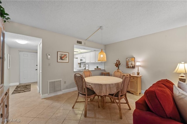 tiled dining area featuring a textured ceiling