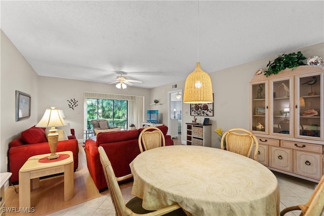 dining room with light tile patterned flooring, ceiling fan, and a textured ceiling