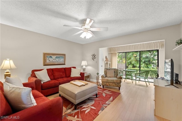 living room with a textured ceiling, light hardwood / wood-style floors, and ceiling fan