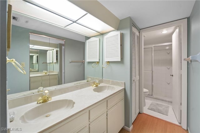 bathroom with tiled shower, toilet, wood-type flooring, vanity, and radiator heating unit