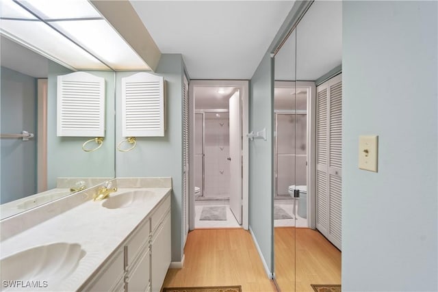 bathroom featuring vanity, wood-type flooring, toilet, and walk in shower