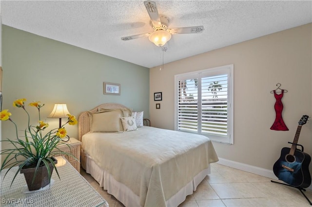 tiled bedroom with ceiling fan and a textured ceiling