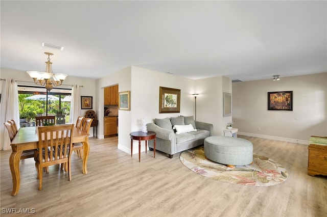 living room with light hardwood / wood-style flooring and a notable chandelier