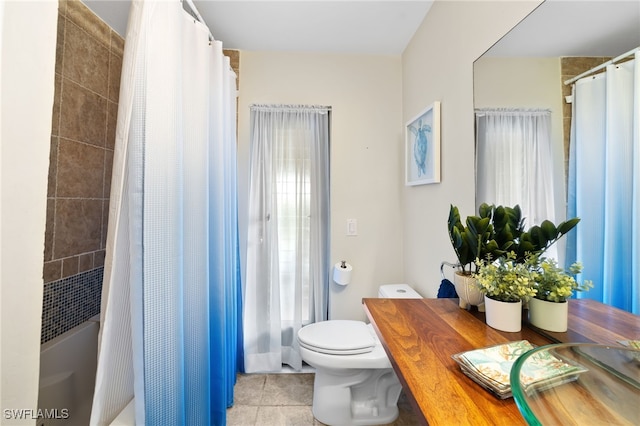 bathroom with toilet, tile patterned floors, and a wealth of natural light