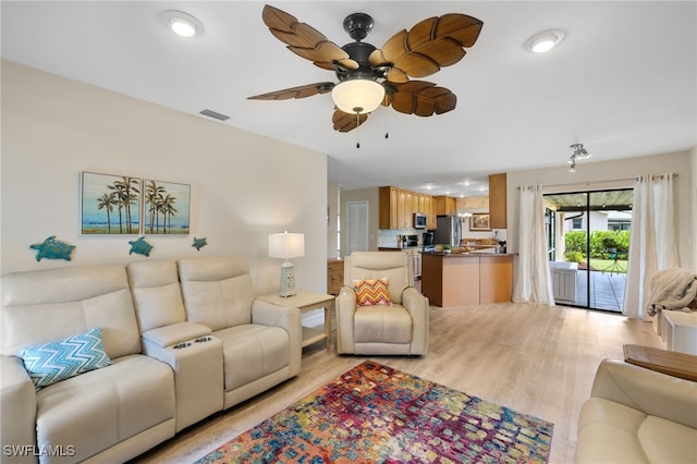 living room featuring ceiling fan and light hardwood / wood-style floors