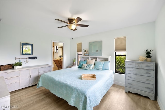 bedroom with ceiling fan, ensuite bathroom, and light wood-type flooring