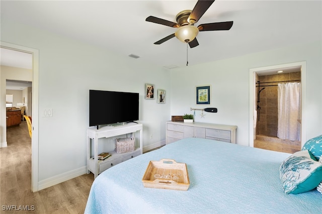 bedroom with light wood-type flooring, connected bathroom, and ceiling fan