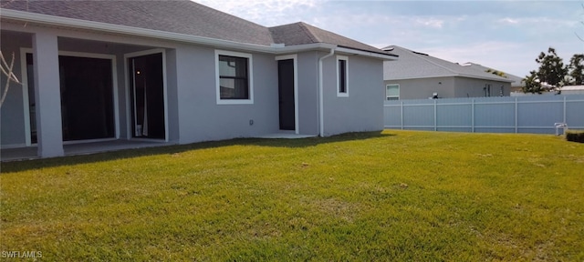 rear view of house featuring a lawn