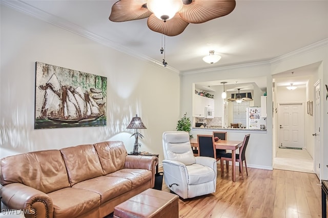 living room with ceiling fan, crown molding, and light hardwood / wood-style floors