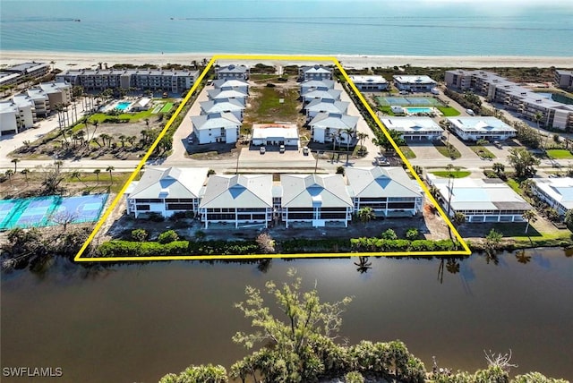 drone / aerial view with a water view and a beach view