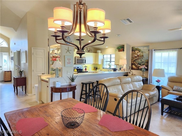 dining area with a healthy amount of sunlight, light tile patterned floors, and a notable chandelier