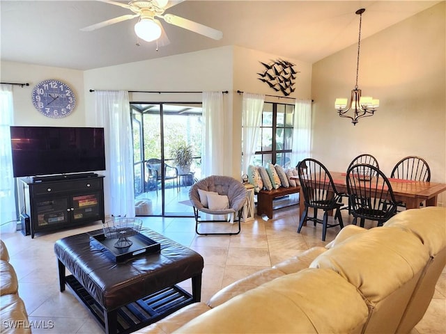 living room with ceiling fan with notable chandelier, light tile patterned flooring, and vaulted ceiling