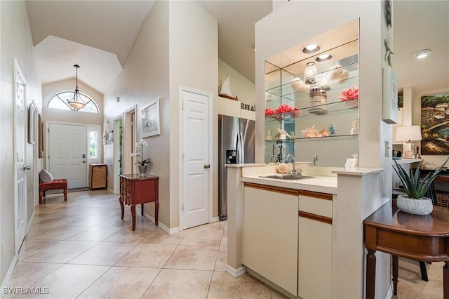 bathroom with tile patterned floors, high vaulted ceiling, and vanity