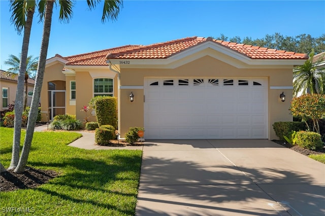 mediterranean / spanish house featuring a garage and a front yard