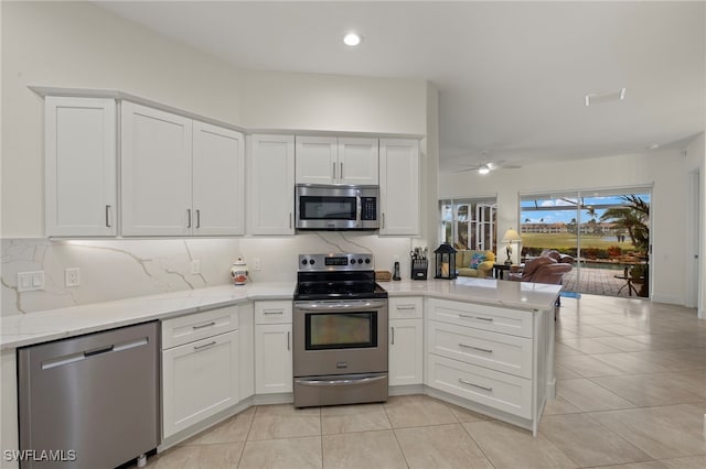 kitchen featuring white cabinetry, backsplash, stainless steel appliances, and kitchen peninsula