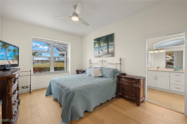 bedroom featuring ceiling fan, light hardwood / wood-style floors, and ensuite bath