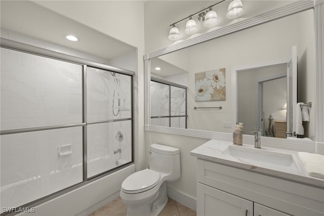 full bathroom featuring tile patterned flooring, enclosed tub / shower combo, vanity, and toilet