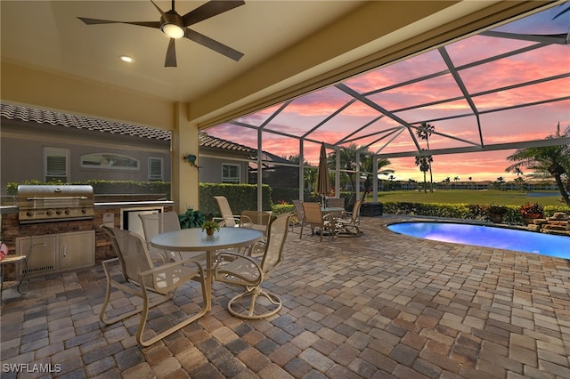 pool at dusk featuring a lanai, area for grilling, grilling area, and a patio area